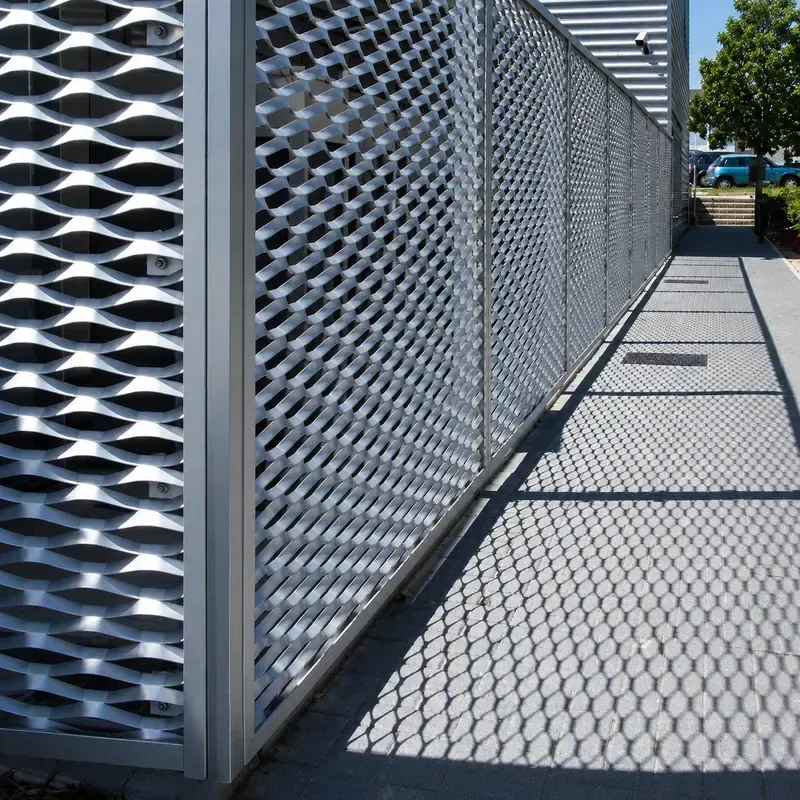 Expanded metal perimeter screen beside a commercial walkway