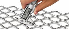 Digital caliper checking a carbon steel expanded metal strand