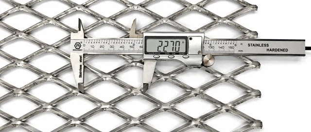 Digital caliper measuring a stainless steel expanded metal diamond opening