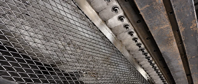 Diamond expanded metal mesh alongside industrial machinery and steel beams