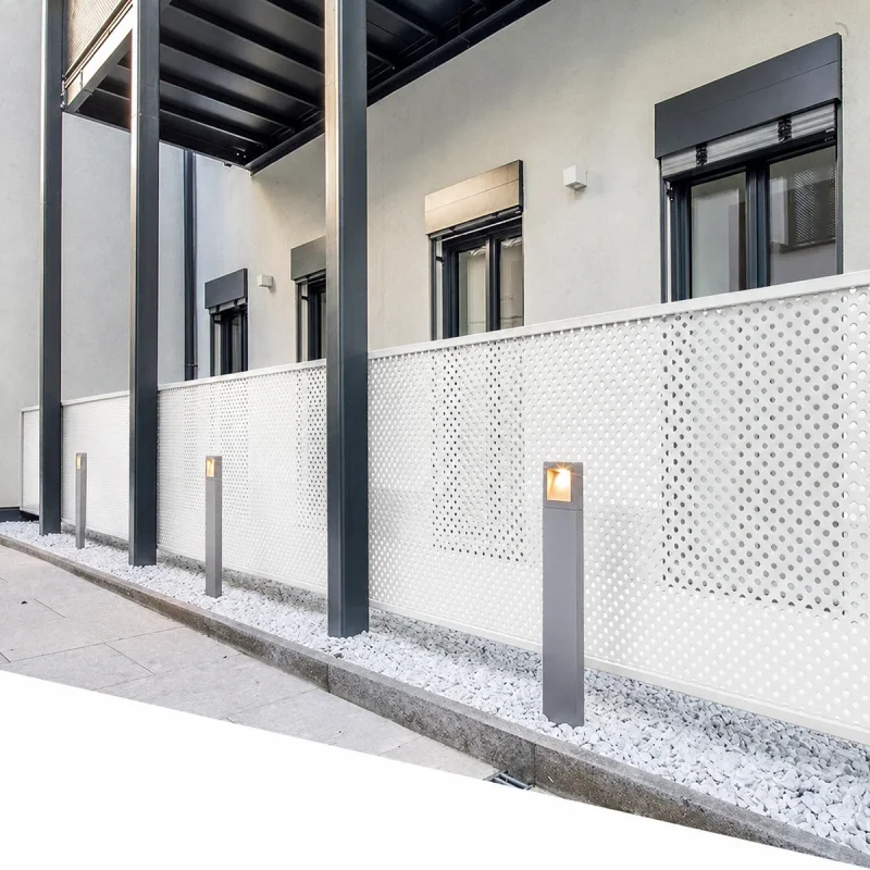 White perforated metal balcony screen panels on a modern building