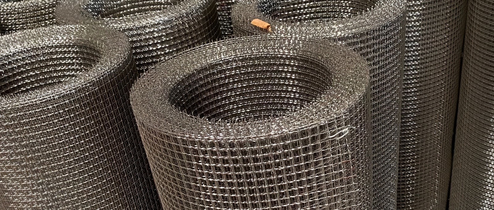 Stainless steel crimped wire mesh rolls showing woven square openings