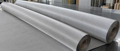 Two stainless steel filter mesh rolls on a metal worktable with fine woven wire texture