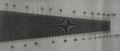 Fine stainless steel woven wire mesh viewed against a tapered mesh-count scale