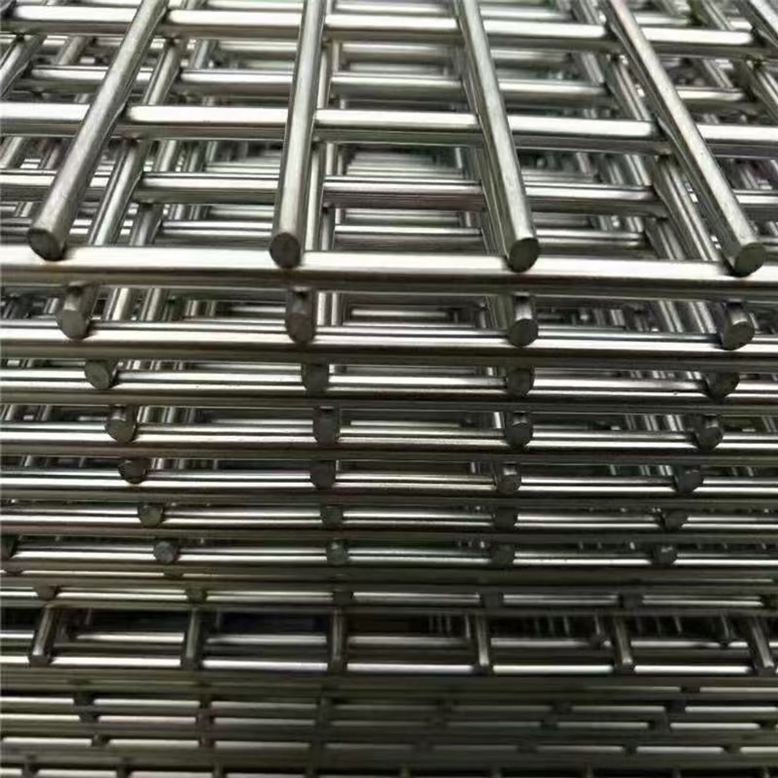 Stacked stainless steel welded wire mesh panels showing rigid welded intersections