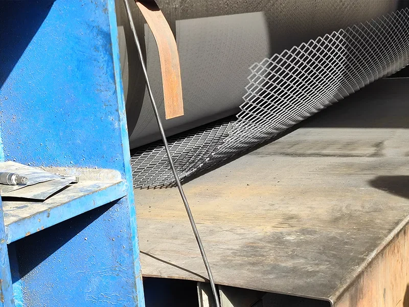 Expanded metal sheet passing through a forming machine
